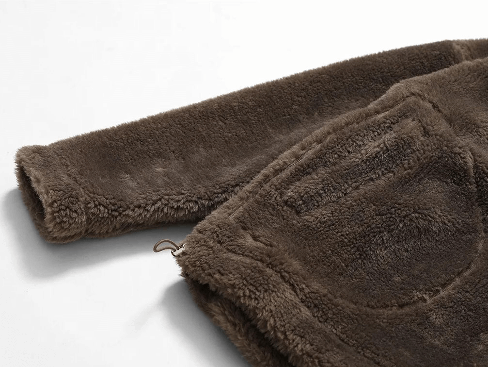 Close-up of long-sleeved outdoor loose fitting lamb fleece jacket in brown, showing the soft polyester texture and full sleeve design.