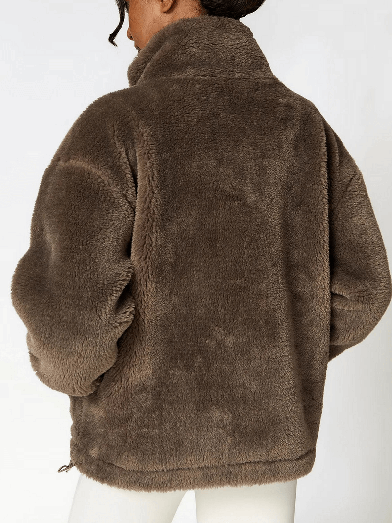Woman wearing long sleeved outdoor loose fitting lamb fleece jacket in brown, perfect for yoga and outdoor activities.