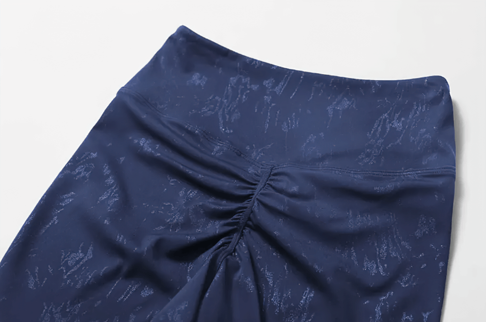 Close-up of navy seamless activewear shorts with textured pattern and gathered detail, part of women's two-piece workout outfit.