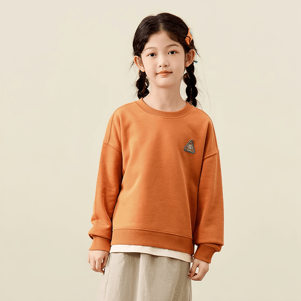 Trendy kid wearing a long-sleeved mountain-themed sweatshirt, perfect for adventurous spirits. Fun, vibrant design on soft, layering-friendly fabric.