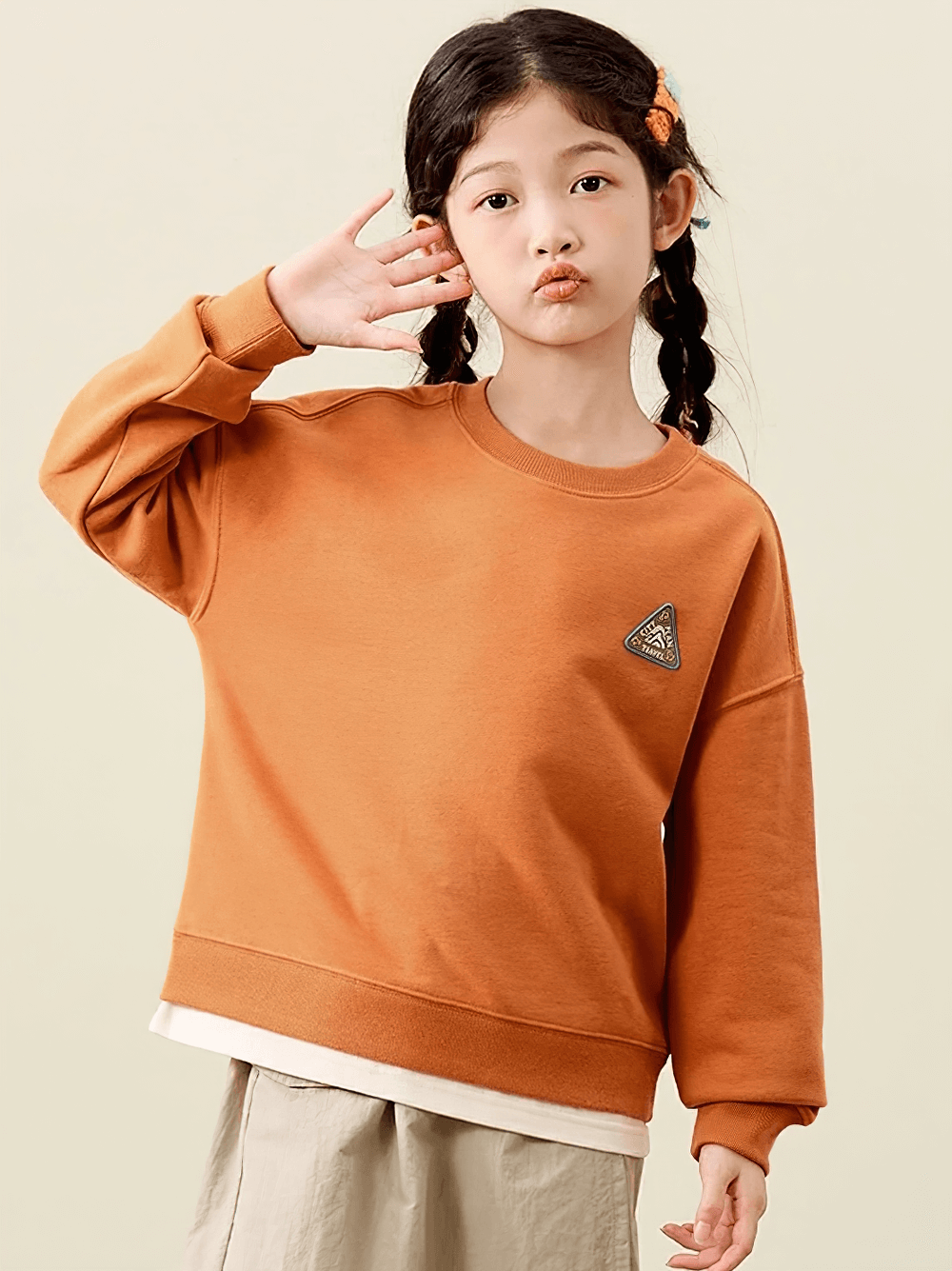 Trendy kid wearing a cozy orange long-sleeved sweatshirt, perfect for adventures and everyday fun.