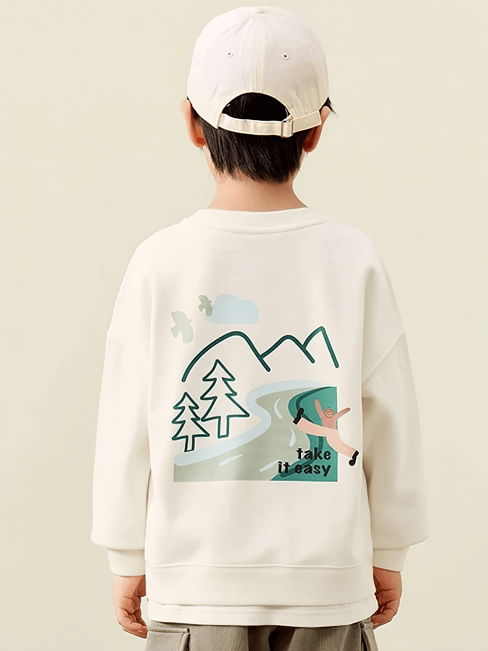Child wearing trendy long-sleeved sweatshirt with mountain and nature design, "Take it Easy" print, perfect for adventurous kids.
