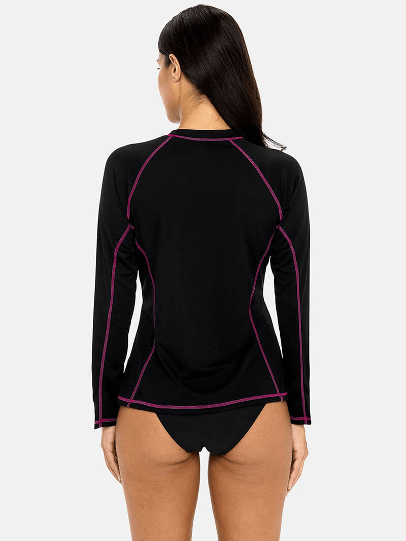 Back view of women's black long sleeves surf top with UPF 50+ protection and purple stitching, perfect for stylish beachwear.