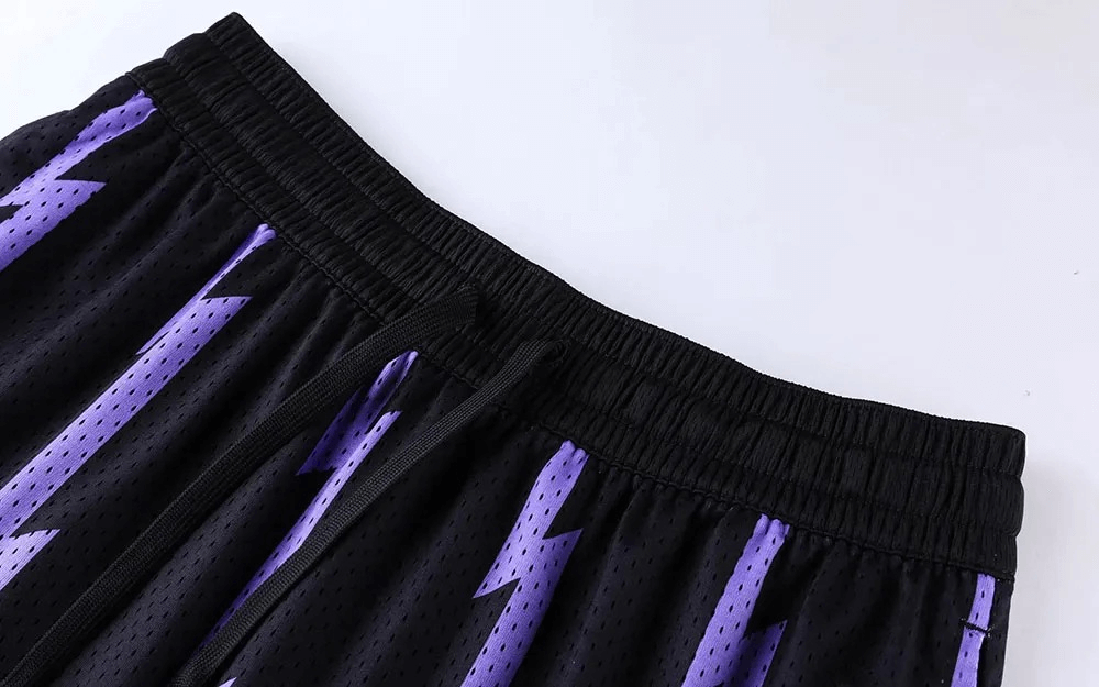 Black basketball shorts with purple lightning print, elastic waistband, and breathable mesh fabric for comfort during workouts.