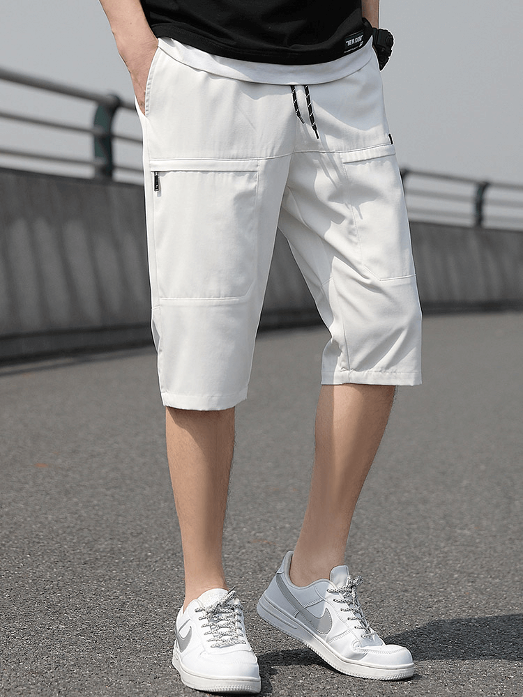 White loose breathable drawstring calf-length shorts for men with side pockets, showcasing comfort and style.