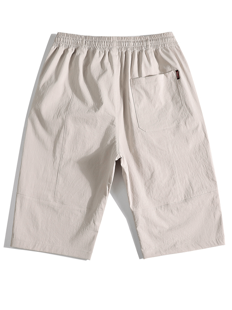 Men's loose breathable drawstring calf-length shorts in khaki. Comfortable, stylish, with pocket detail. Perfect for casual wear.