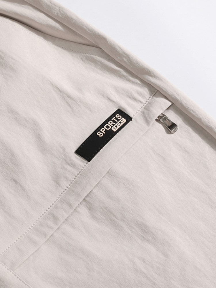 Close-up of white calf-length shorts with drawstring and pocket, featuring 'Sports' label for breathable and comfortable men's wear.