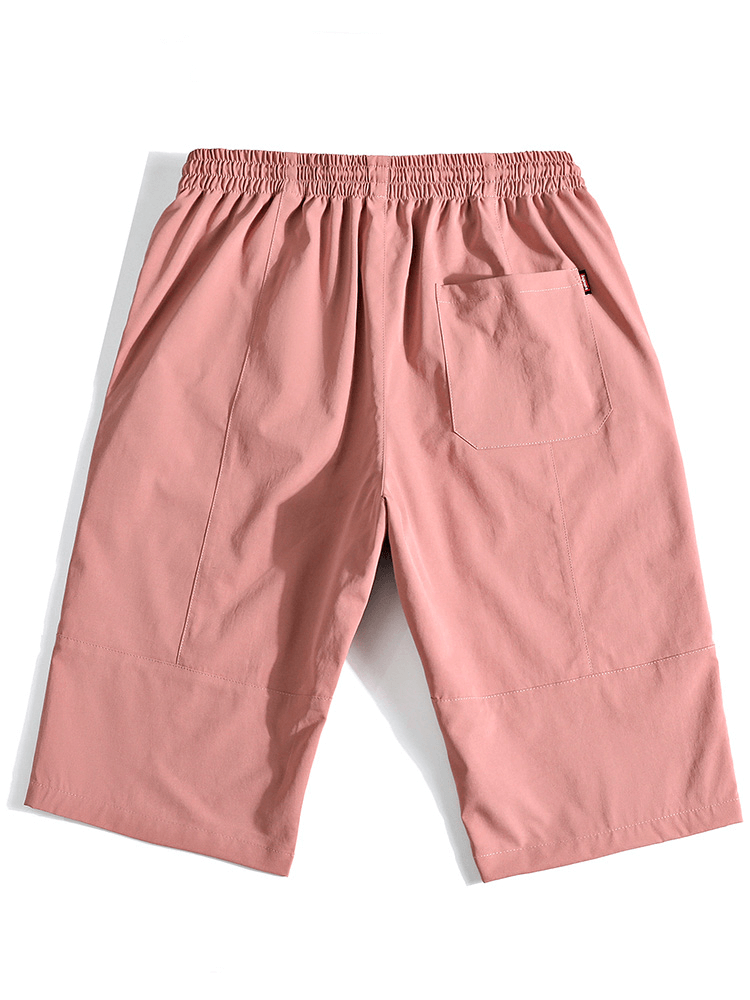 Pink loose breathable drawstring calf-length shorts for men, featuring pockets and elastic waistband.