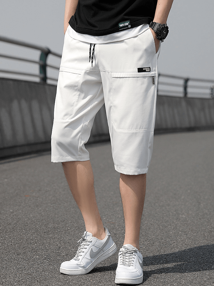 White loose breathable drawstring calf-length shorts for men with pockets, featuring a stylish fit and lightweight materials.