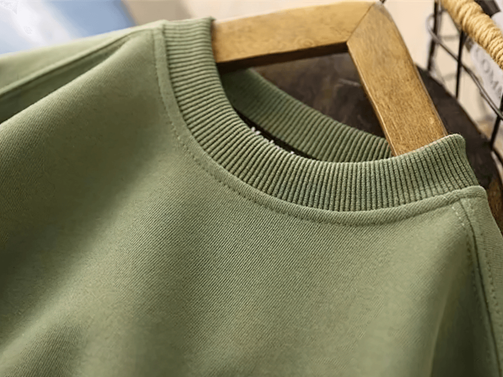 Close-up of green loose cotton pullover with ribbed neckline, perfect for casual wear and featuring stylish contrast elbow patches, model SF3104.