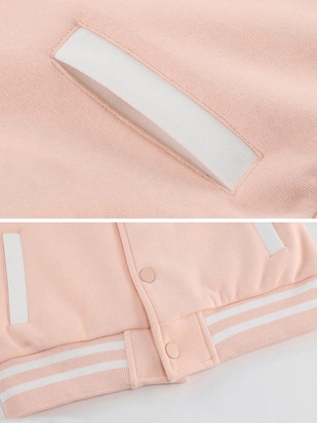 Close-up of pink kids baseball jacket with white striped cuffs and snap buttons, highlighting cotton fabric and pocket detail.