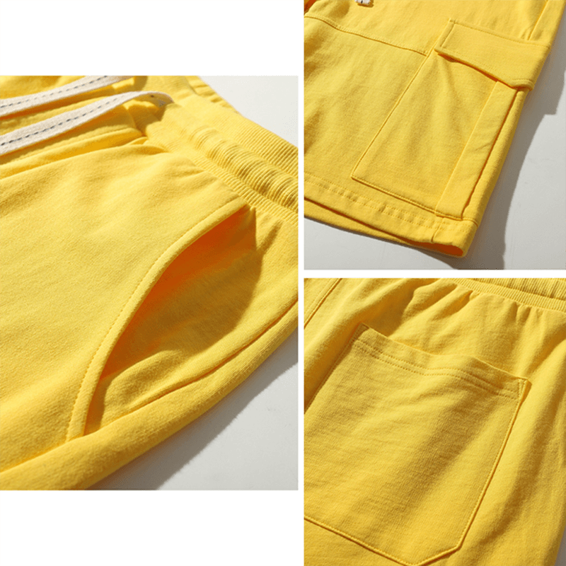 Close-up of yellow multi-pocket breathable men's sports shorts with drawstring closure, showcasing pockets and fabric detail.
