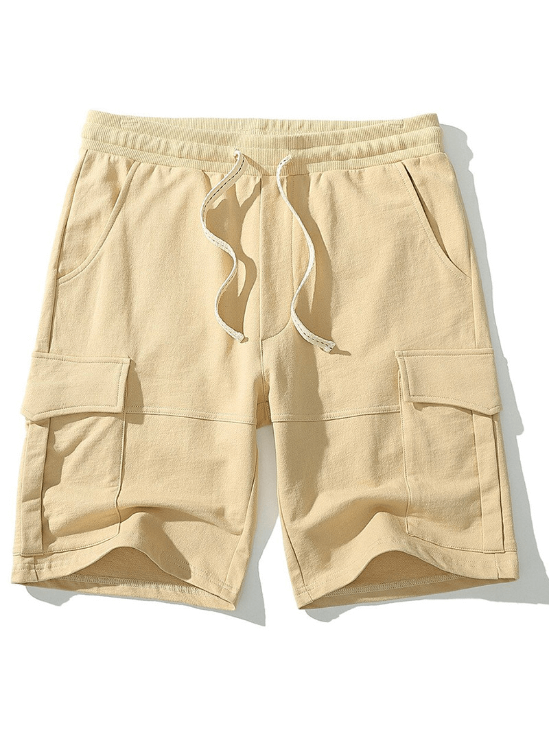 Loose multi-pocket breathable sports shorts for men in beige with drawstring closure, ideal for gym and casual wear.