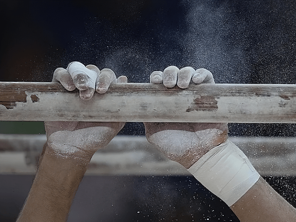 Magnesium Carbonate Gym Chalk Blocks for Training - SF3456 aiding grip on a gymnastics bar with chalky hands.