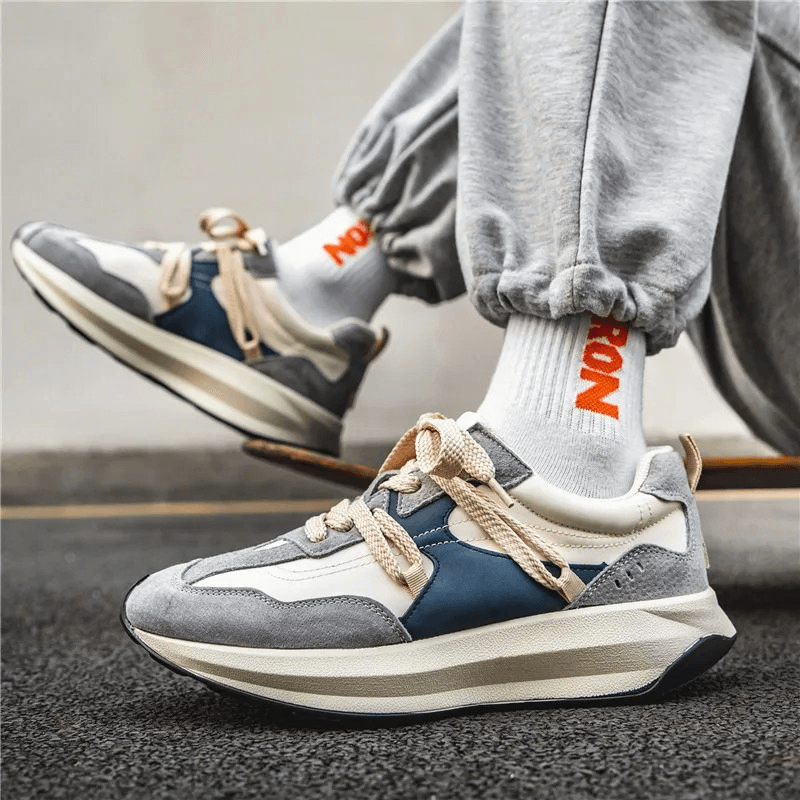 Man wearing breathable sports sneakers on platform while skateboarding, showcasing comfort and style with height-boosting design.