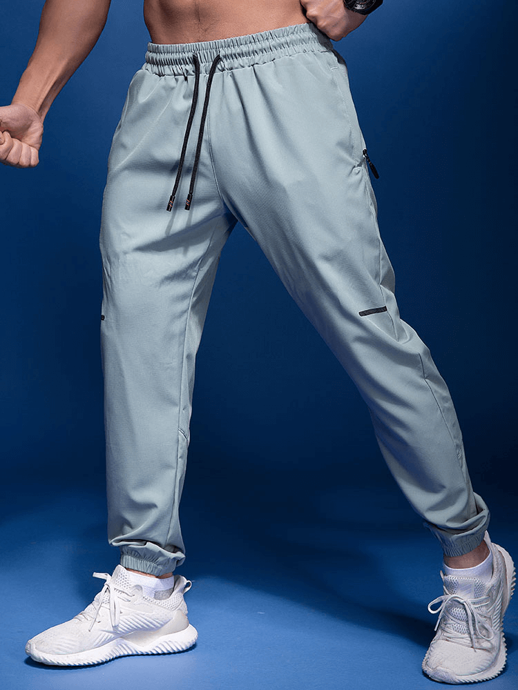 Male elastic waist running joggers with zipper pockets, perfect for active lifestyle, featuring polyester-spandex blend for ultimate comfort.