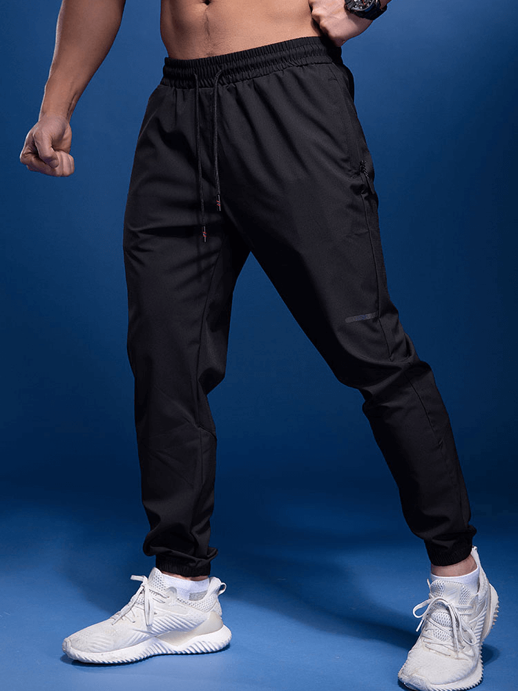 Male sports joggers, elastic waist, zipper pockets, black color, ideal for running, active lifestyle wear.