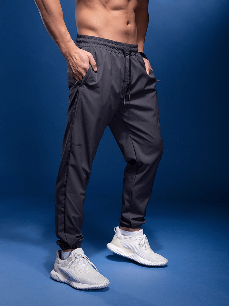 Men's elastic waist sports joggers with zipper pockets, perfect for running and active wear.