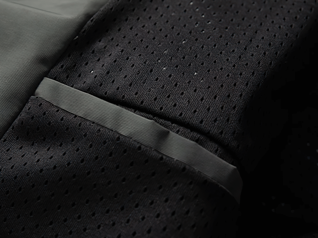 Close-up of black mesh fabric with high-quality stitching detail, showcasing sleek design and durable material of SF2268 jacket.