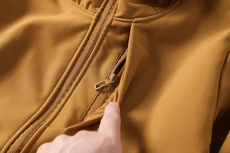 Close-up of a durable waterproof hiking jacket zipper, showcasing polyester fabric quality for outdoor adventures.