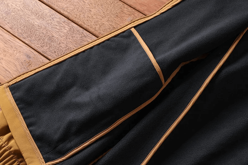 Close-up of a durable black and brown hiking jacket, showcasing its soft cotton lining for outdoor adventures.