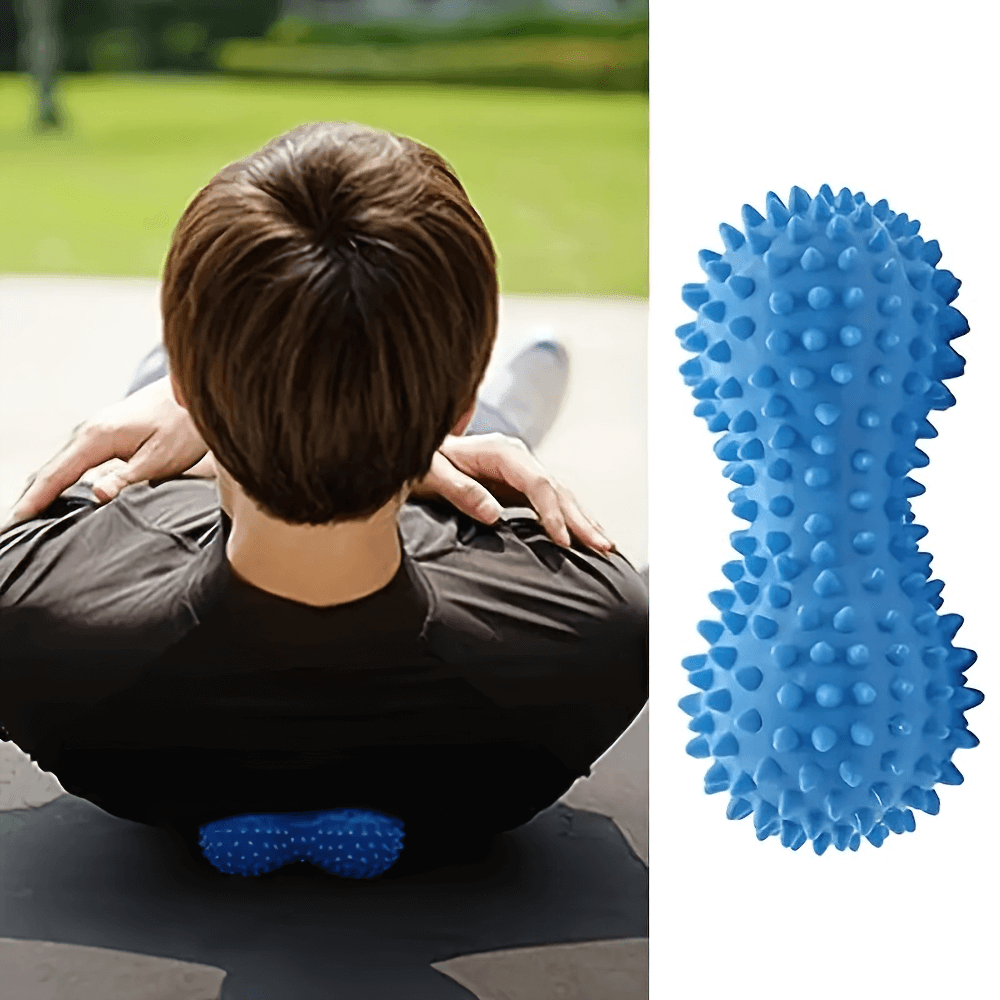 Blue peanut-shaped spiky massage ball for deep tissue muscle relief under back during outdoor relaxation.