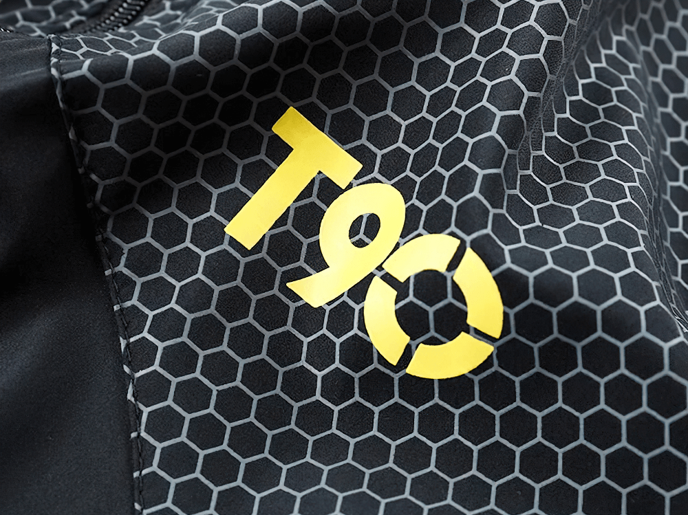 Close-up of T90 branding on men’s sports tracksuit with hexagonal pattern, showcasing stylish design and durable fabric.