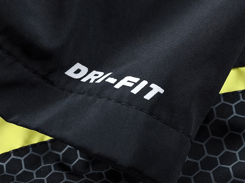 Close-up of black sportswear fabric with honeycomb pattern and "DRI-FIT" label, highlighting its breathable material.