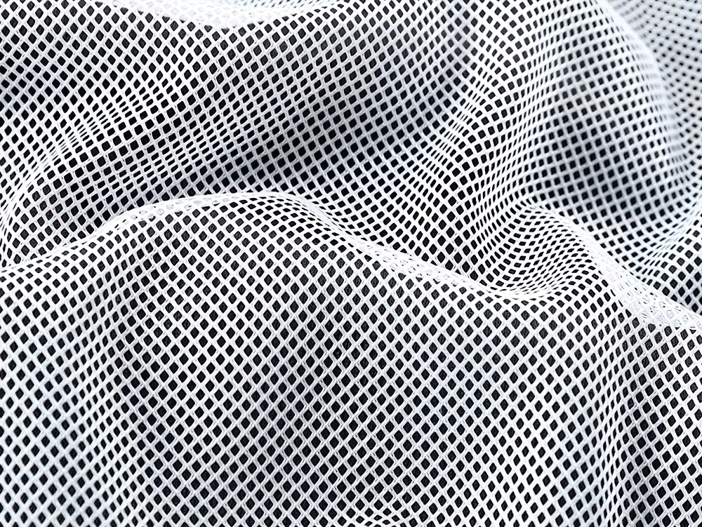 Close-up of white mesh fabric with small geometric patterns, showcasing texture and design