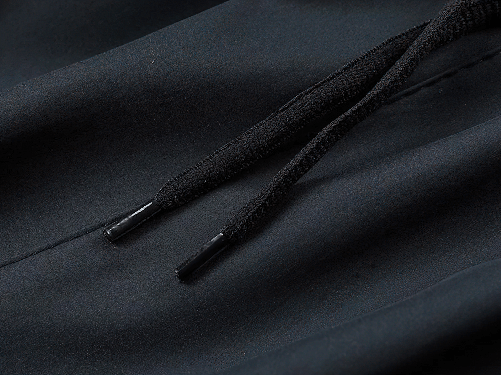 Close-up of drawstring on men's active sports tracksuit pants in black polyester fabric, showcasing durable quality and sleek design.