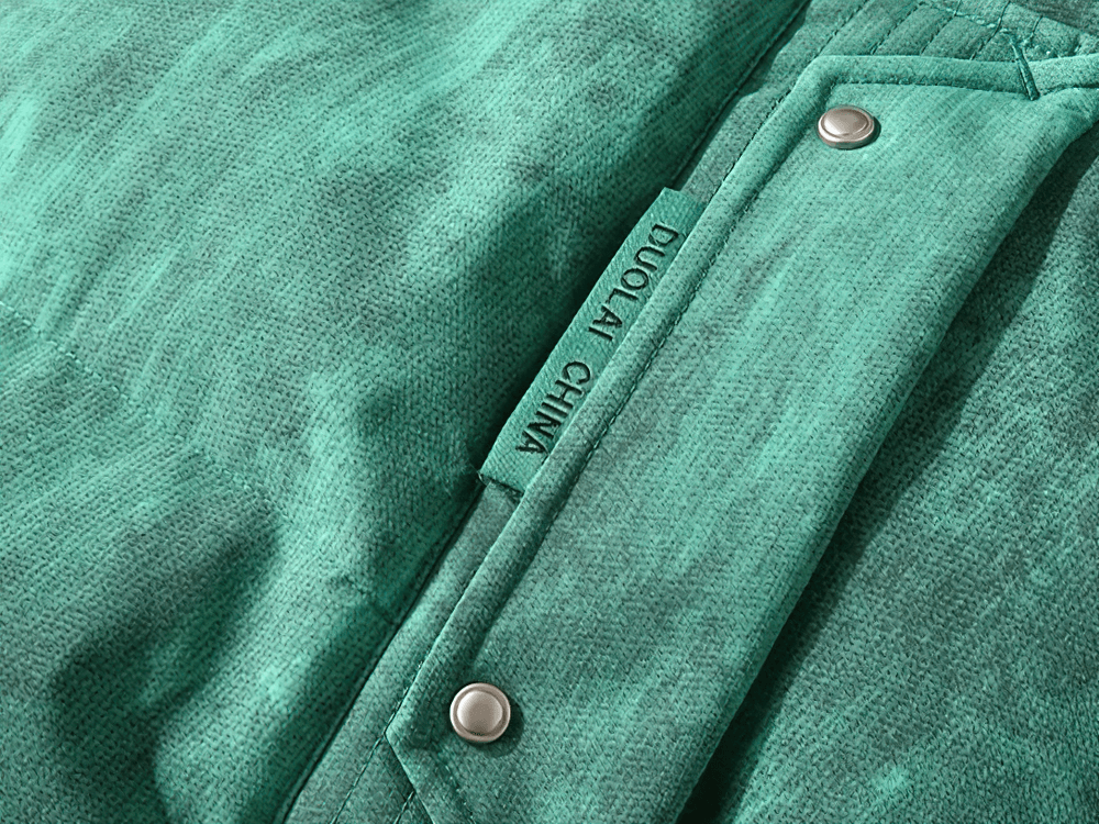 Close-up of green fabric with metallic buttons and 'DUOLAI CHINA' label, showcasing texture and detail of a jacket.