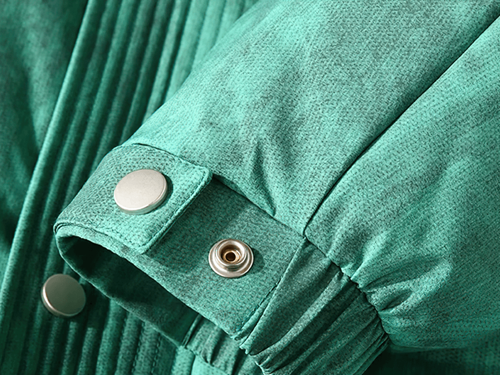 Close-up of green jacket sleeve with button detail and textured fabric.