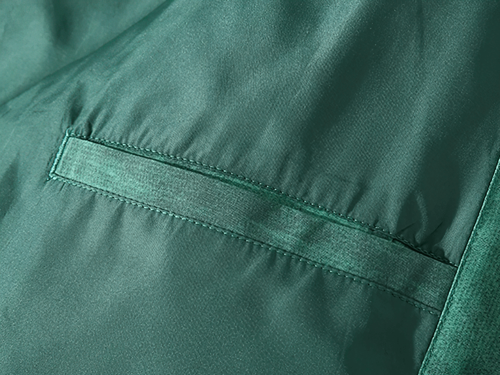 Close-up of green duck down puffer jacket fabric with pocket detail, ideal for stylish winter streetwear. Product SF2260.