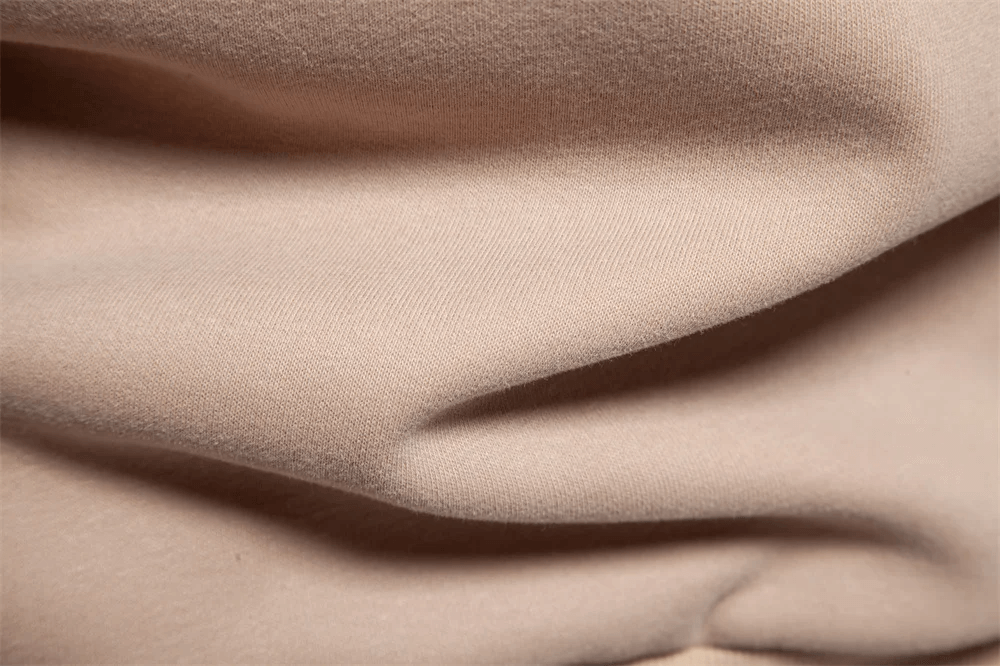 Close-up of soft beige fabric showcasing texture and folds, perfect for fashion and interior design inspiration.