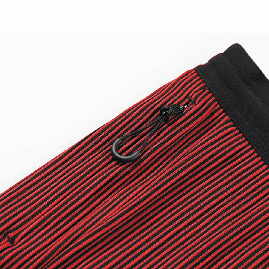 Red and black striped swim trunks with pocket and drawstring detail, perfect for a stylish beach look.