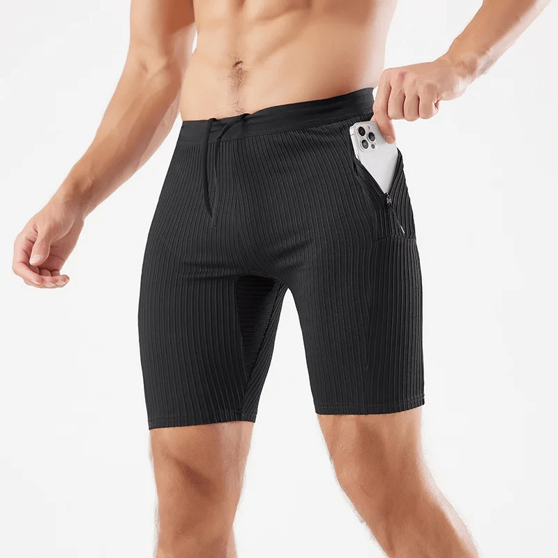 Men’s black quick-dry striped swim trunks with pocket holding a smartphone, perfect for style and functionality at the beach.