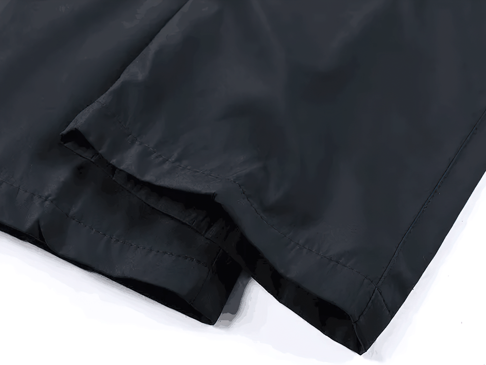 Close-up of lightweight black track pants fabric showing breathable, flexible material ideal for men's sports and outdoor activities.