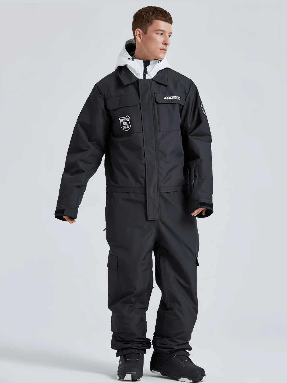 Model wearing men's waterproof snowboard suit with hooded collar, insulated for winter adventures, showcasing durability and style.