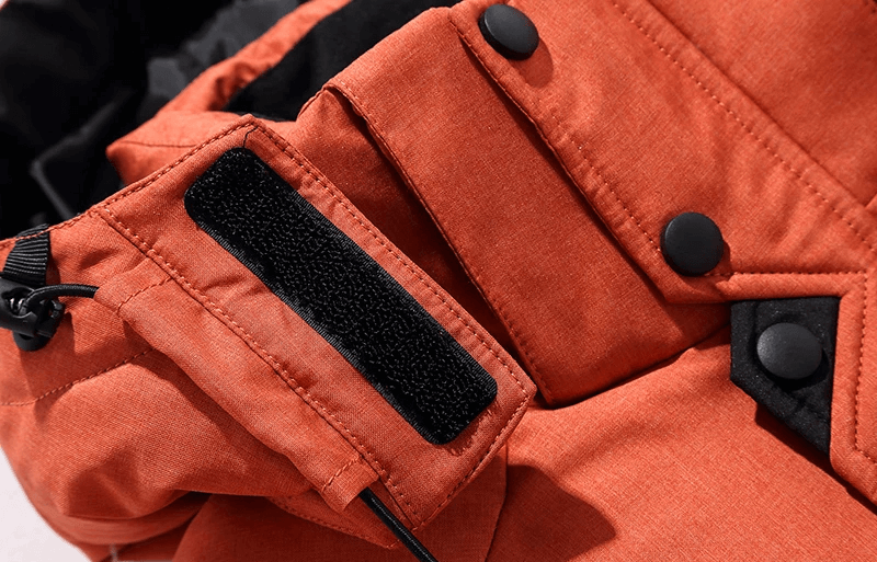 Close-up of a warm, orange hooded jacket with black button details and Velcro strap for men's windproof ski suit, style SF2045.