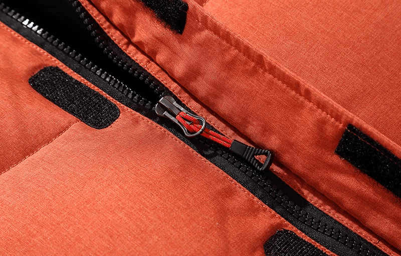 Close-up of orange ski jacket zipper with velcro on Men's Windproof Ski Suit SF2045, showcasing durable polyester material.