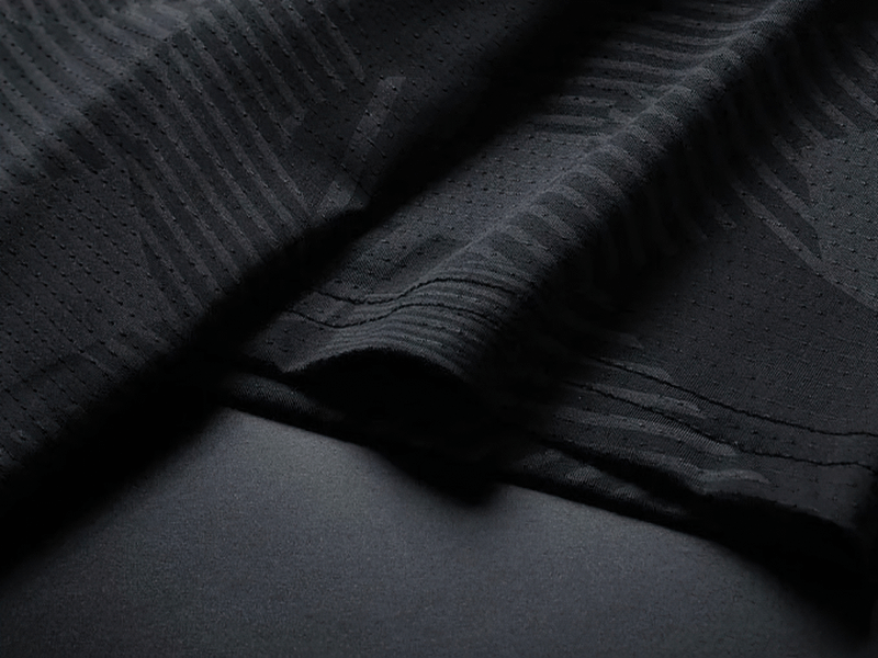 Close-up of black patterned dry-fit fabric for men's active t-shirt, SF1986, showing breathable texture and moisture-wicking design.