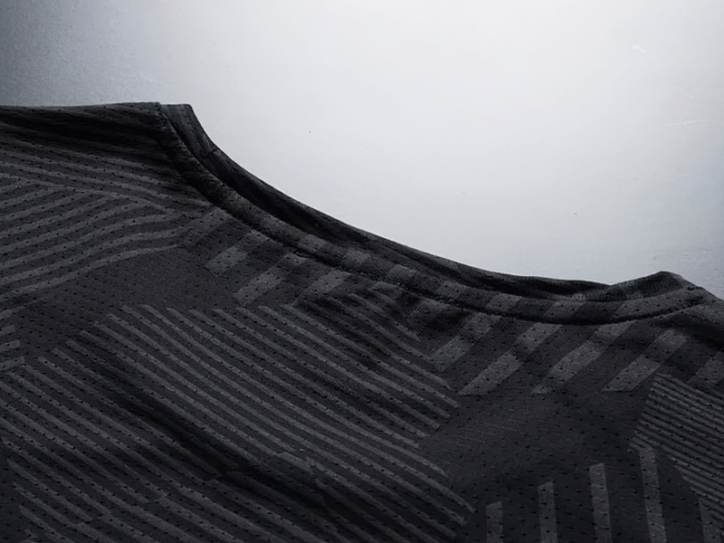 Close-up of men's active dry-fit crew neck patterned t-shirt in black, featuring moisture-wicking polyester fabric for comfort and coolness.