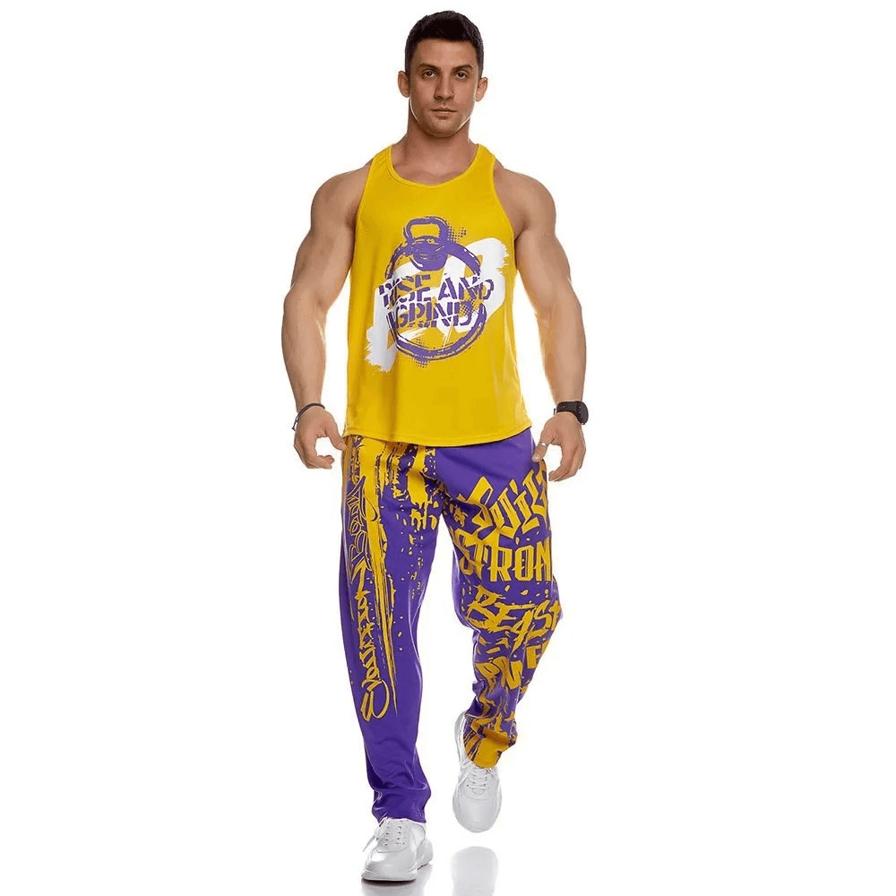 Man wearing yellow tank top and purple-yellow athletic drip print sweatpants, perfect for gym workouts.