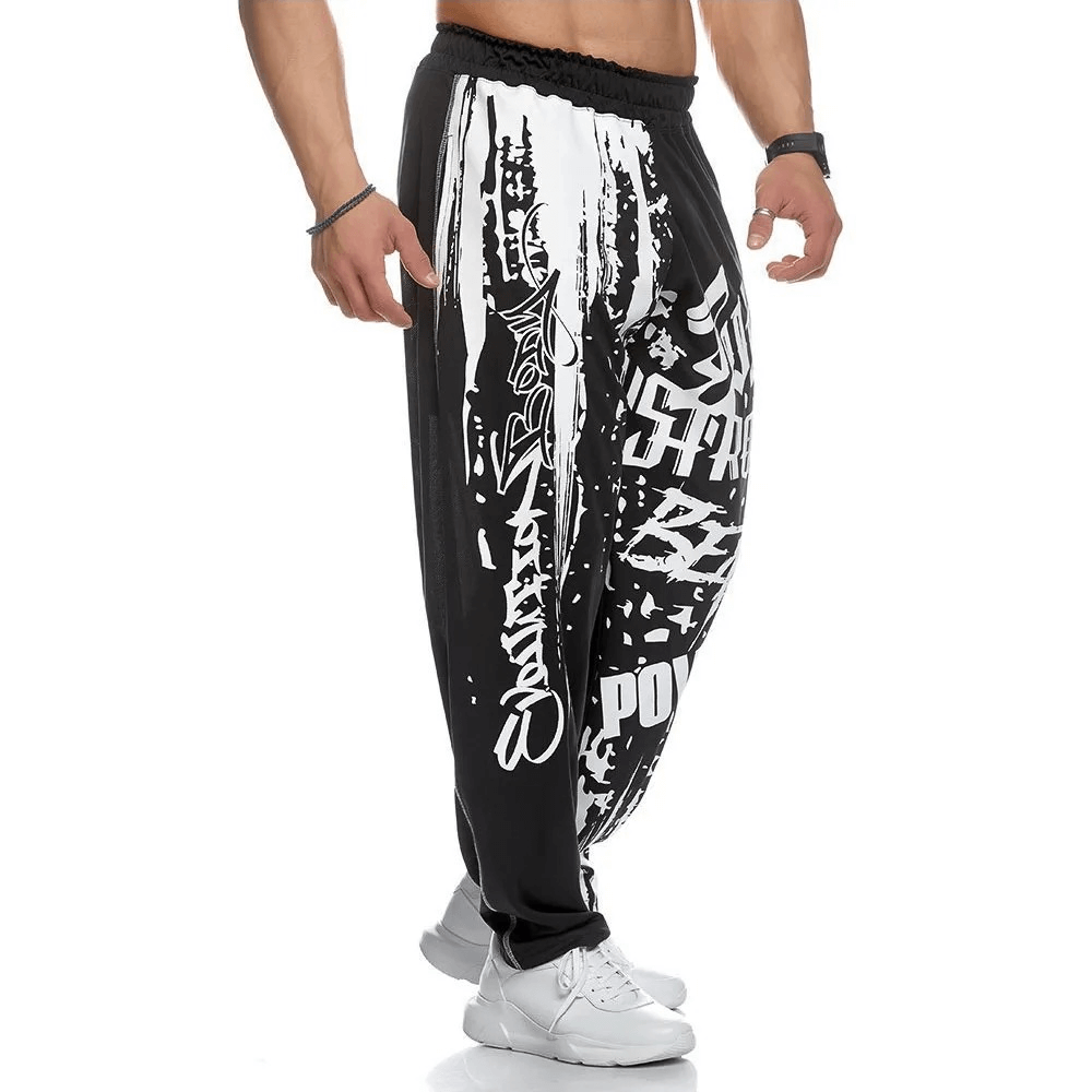 Men's black and white athletic drip print sweatpants with polyester fabric and drawstring, perfect for gym workouts and running.