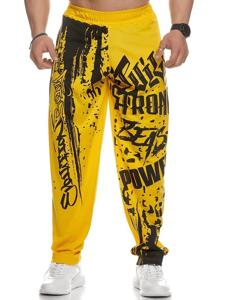 Men's yellow athletic drip print sweatpants for gym workouts, featuring bold style and polyester fabric for comfort and performance.