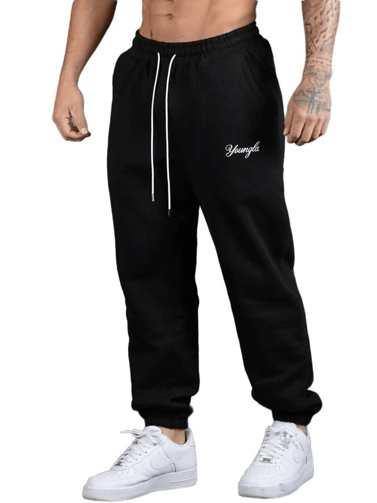 Men's durable athletic fit joggers with drawstring waistband, mid waist, and stylish letter detailing, in breathable black polyester.