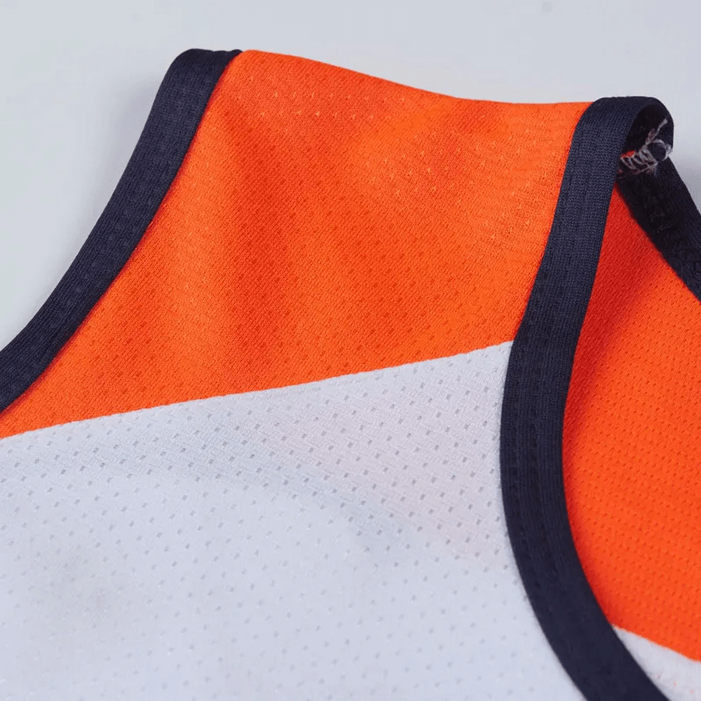 Close-up of a men's athletic mesh tank top in orange and white with navy trim