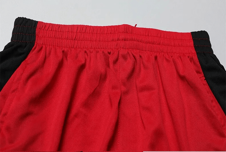 Close-up of men's red and black soccer shorts with elastic waistband.
