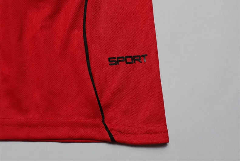 Close-up of red sports jersey with black piping and 'SPORT' lettering, showcasing performance fabric designed for athletic wear.
