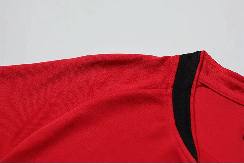 Close-up of red and black O-neck athletic soccer jersey fabric.